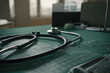 © Deris Firmansyah - A serene medical setting with a stethoscope on a green mat, handwritten notes, and a window letting in soft light