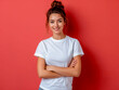 © VISUAL BACKGROUND - A young woman in white t - shirt standing against a red wall.