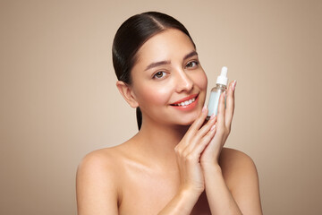 beautiful elegant woman holding a cosmetic jar of oil serum or hyaluronic acid in her hand. perfect 
