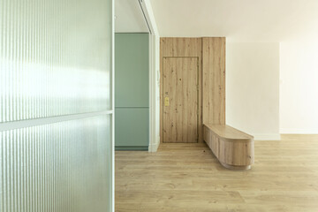 Front image of a modern design open kitchen with pastel green furniture, with an extendable glass and metal screen