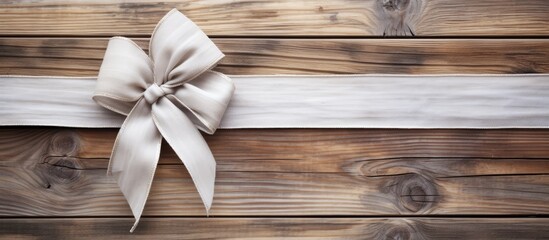 Fototapete - A festive white bow adorns a copy space image of a rustic wooden background