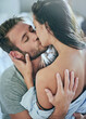 © peopleimages.com - Love, romance and couple in bed with kiss, affection and and morning bonding in apartment. Relationship, man and woman in bedroom with intimate embrace, passion and relax with care on weekend in home