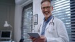 © MP Studio - Smiling Doctor Holding a Tablet