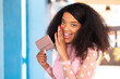 © luismolinero - Young African American woman holding a wallet at outdoors whispering something
