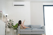 © Naypong Studio - Young woman enjoying air conditioning at home