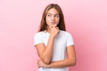 Wall Mural - Little caucasian girl isolated on pink background thinking an idea while looking up