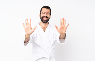 Wall Mural - Young man doing karate over isolated white background counting ten with fingers