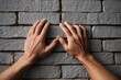© ModernGallery - man's hands on the background brick wall. man putting his hands on brick wall.
