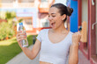 © luismolinero - Young pretty woman with a bottle of water at outdoors celebrating a victory