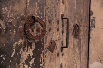 Vintage antique door with keyhole and ring handle. Antique wooden door with a forged metal lock and handle