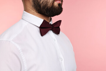 Wall Mural - Man in shirt and bow tie on pink background, closeup