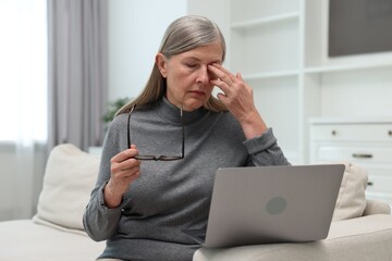 Poster - Overwhelmed woman with laptop sitting on sofa at home