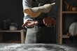 © New Africa - Woman tossing pizza dough at table in kitchen, closeup