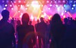 © OLGA - Silhouetted concert crowd against vibrant stage lights.