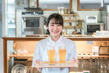 グラスの生ビールを持つ女性シェフ・調理師（アルコール・お酒）