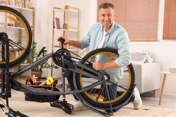 Wall Mural - Mature man repairing bicycle at home