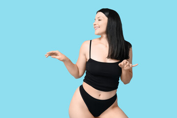 Poster - Body positive young woman in underwear on blue background