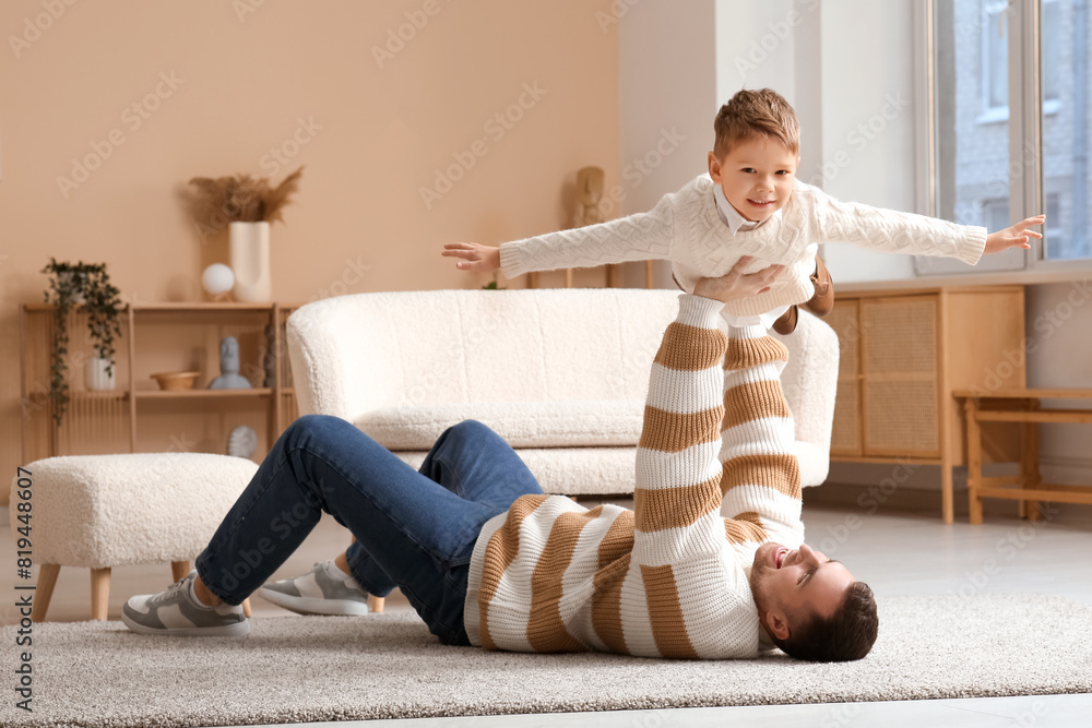 Happy father and his little son having fun together at home