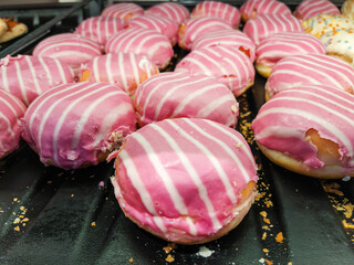 Wall Mural - Pink Striped Glazed Donuts in Bakery