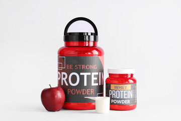 Poster - Bottles with protein powder and apple on light background