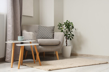 Poster - Interior of light living room with grey armchair and tables