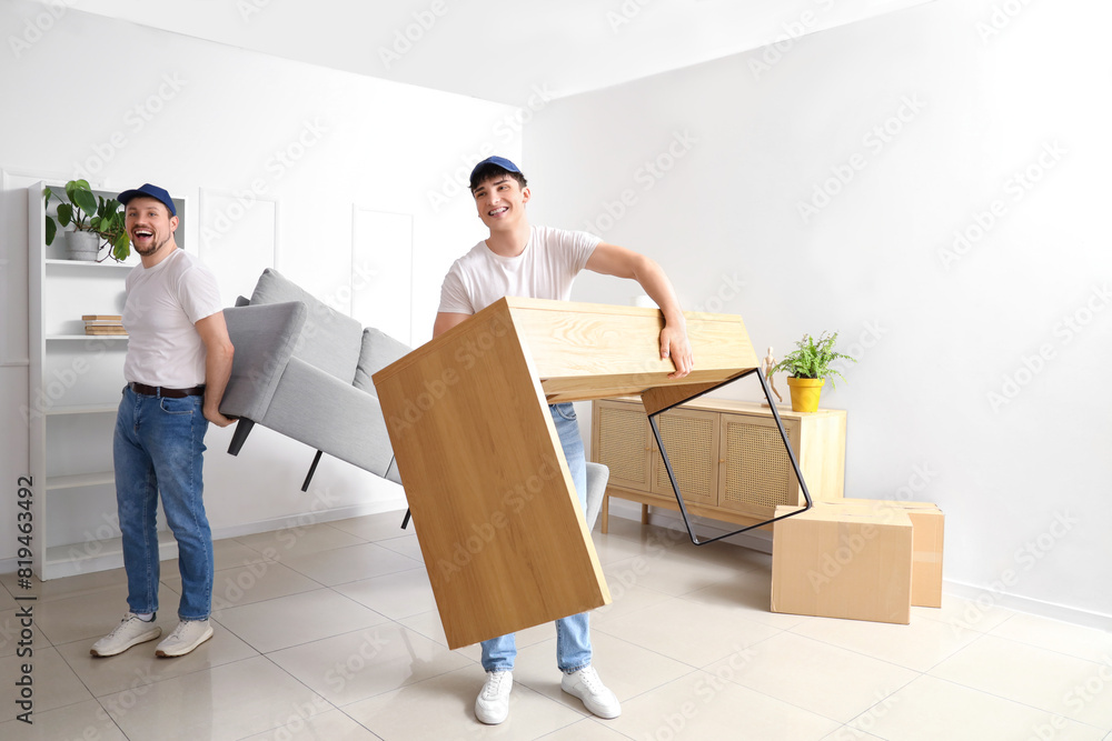 Loaders carrying furniture in room