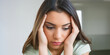 © Barry - Young woman, holding her head in her hands at home, suffering from a headache due to stress and worry.