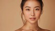 © peerawat - A beautiful young Asian woman with clean, fresh skin on a beige background. Her radiant complexion highlights the importance of face care, facial treatments, and cosmetology. Perfect for beauty