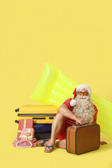 Sticker - Santa Claus with bags and gifts on yellow background. Christmas in July