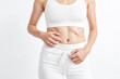 © Rysak - Woman in white top and pants touching her stomach