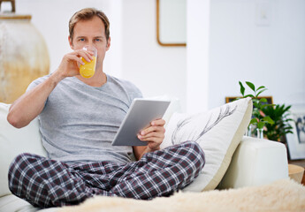 Poster - Portrait, orange juice and man with tablet, pajamas and relax with morning news, digital app and connection. Person, home or guy on weekend break, nutrition and tech with health, wellness or internet