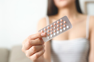 Wall Mural - Woman hands opening birth control pills in hand. Eating Contraceptive Pill.