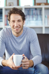 Sticker - Portrait, home and man with coffee, smile and sitting on sofa, happiness and espresso with weekend break. Person, apartment and guy with morning tea in living room, wellness and relax with cappuccino