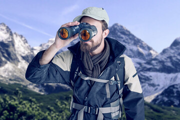 man, hiking and binoculars on mountain snow, search and travel in winter for sightseeing in nature. 