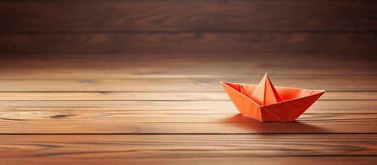 Wall Mural - An adorable origami paper boat displayed on a wooden surface with a clear copy space image available
