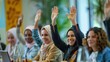 © sambath - Multiethnic businesswomen in a modern office, raising their hands in agreement during a meeting.