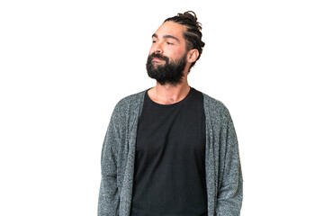 Wall Mural - Young man with beard over isolated chroma key background having doubts while looking side