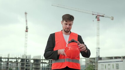 Man puts on work clothes, checking process at construction site