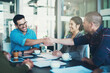 © peopleimages.com - Company, handshake and meeting for deal, crm discussion and business with paperwork and thank you. Office, workers or employees with teamwork or collaboration in workplace for partnership or startup