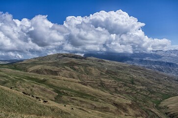 Wall Mural - Scenic view of a mountainous landscape with rolling hills covered in clouds