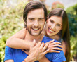 © peopleimages.com - Couple, portrait and nature hug or together for relationship, bonding love and care in outside date for romance. Park, trees and summer holiday with support, happy and smile for quality time