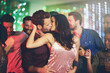 © peopleimages.com - Couple, kiss and dance in club at night on date with love in relationship. People, hug and embrace together in celebration at disco, party or relax at rave with techno music festival and lights