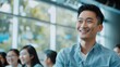 © Dara - Smiling Asian young professional presenting innovative building concepts to an engaged audience in a modern conference room.