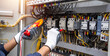 © A Stockphoto - Electricity and electrical maintenance service, Engineer hand holding AC voltmeter checking electric current voltage at circuit breaker terminal and cable .