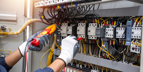 Wall Mural - Electricity and electrical maintenance service, Engineer hand holding AC voltmeter checking electric current voltage at circuit breaker terminal and cable .	
