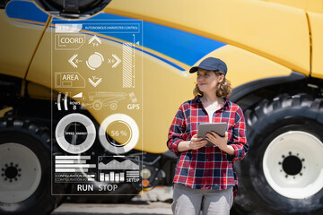 Poster - Woman farmer with digital tablet on a background of autonomous harvester. Smart farming concept