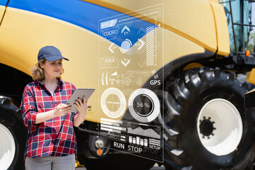 Poster - Woman farmer with digital tablet on a background of autonomous harvester. Smart farming concept.