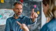 © iuricazac - Man in blue shirt with gray hair and beard pointing at a whiteboard with a serious expression engaged in a discussion with a woman in a blue shirt.