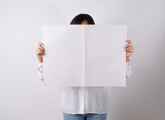 Woman reading mockup of blank newspapers to add your own news isolated on white background.