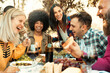 © Davide Angelini - Happy friends having bbq dinner party in garden restaurant - Multiracial young people eating grill meat and drinking red wine in backyard - Food life style concept with guys and girls sitting outdoors